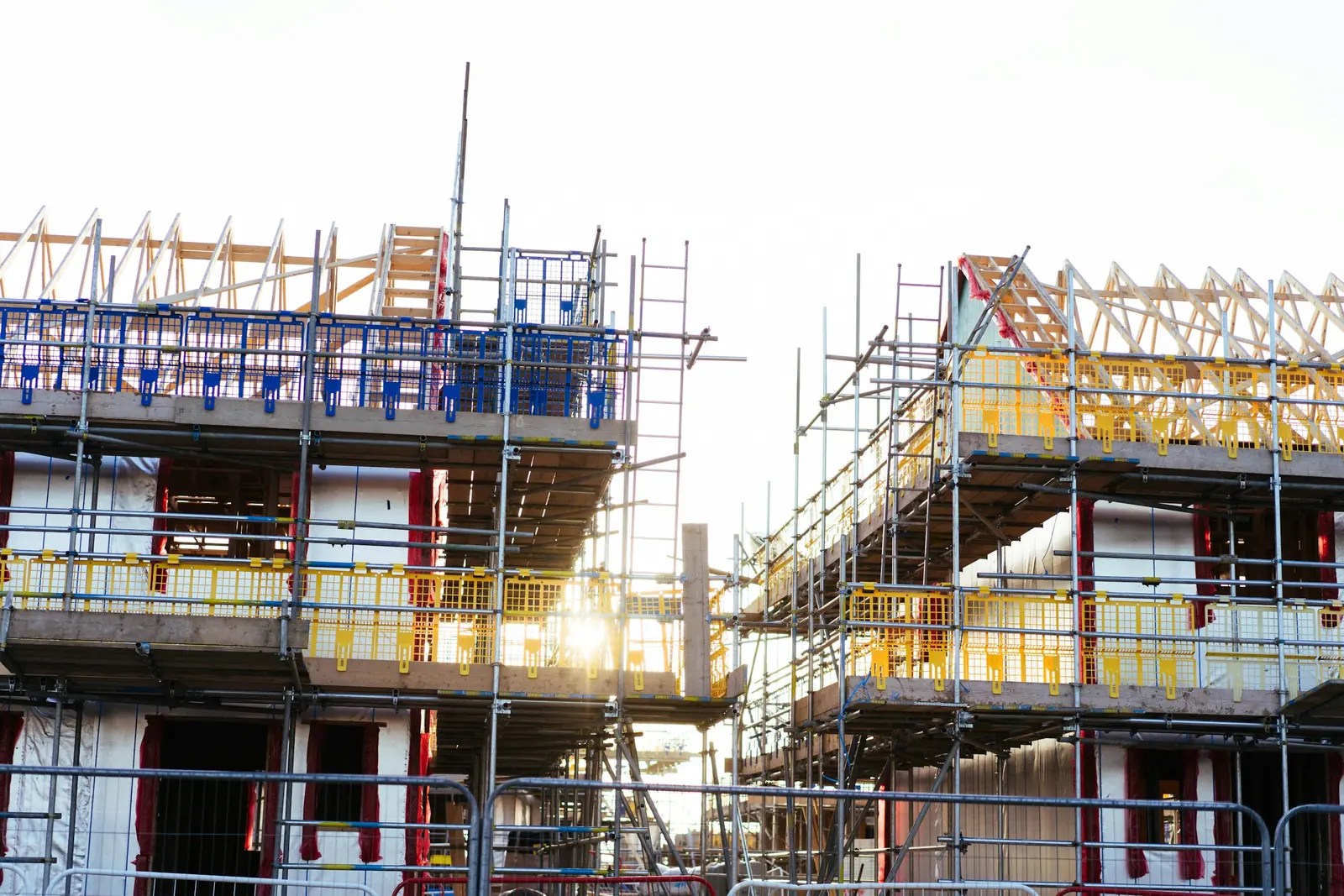 New houses under construction, with timber framing and scaffolding.
