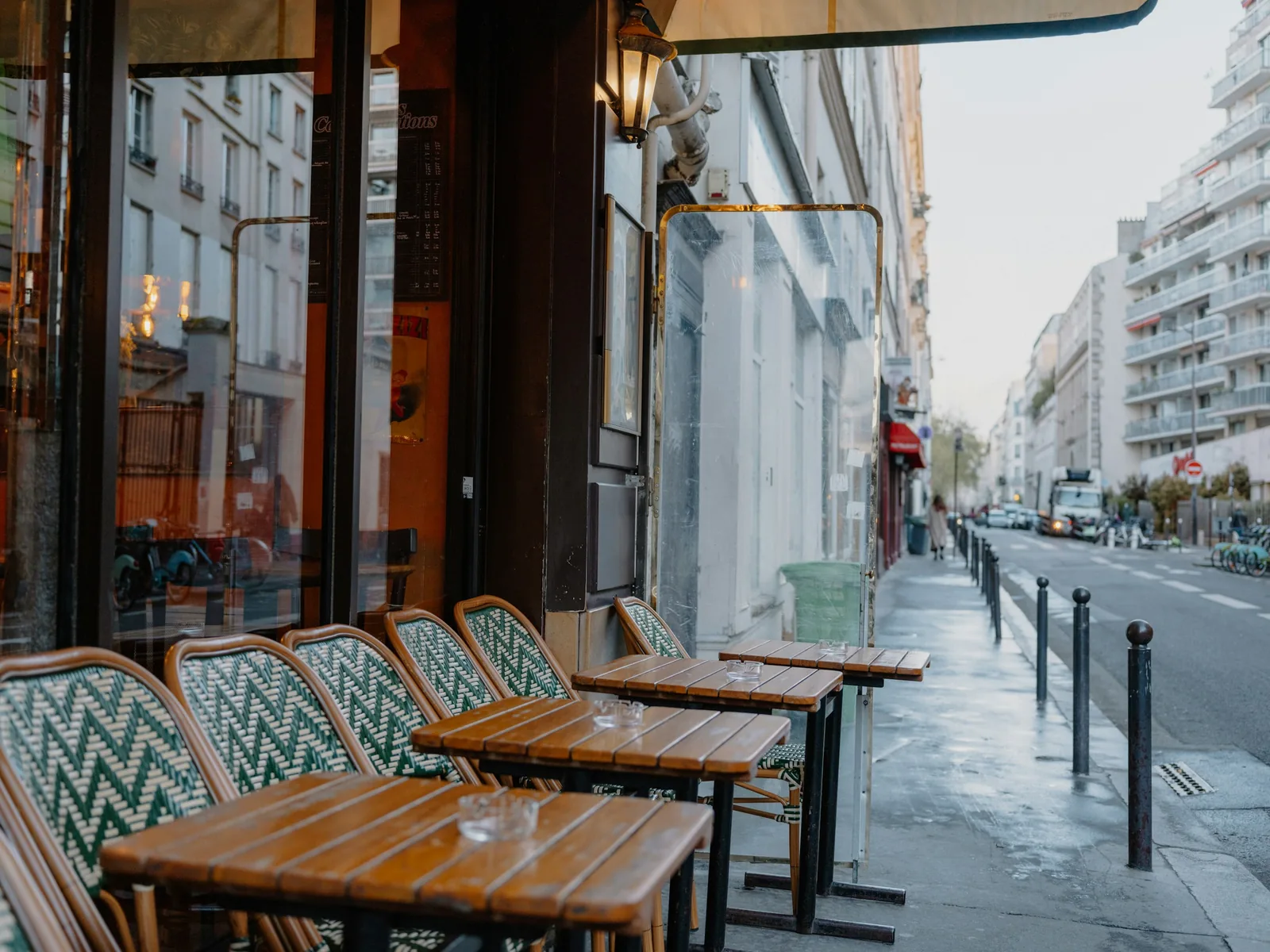 Outdoor cafe tables and chairs along a quiet city street.