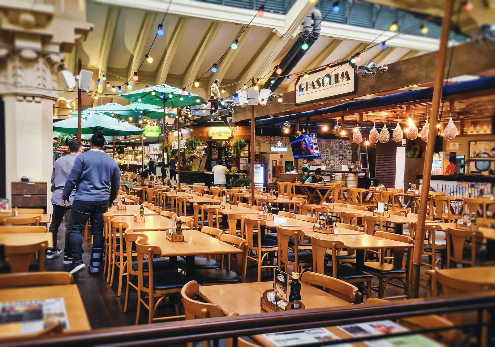 An empty restaurant dining room with wooden tables and chairs.