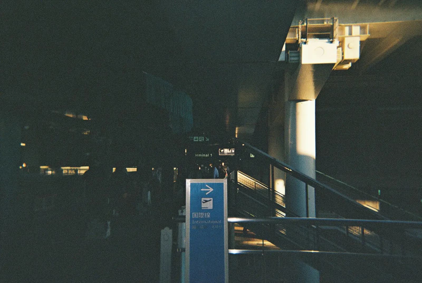 A blue directional sign beside a staircase.